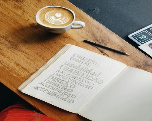Café y libreta sobre mesa de trabajo