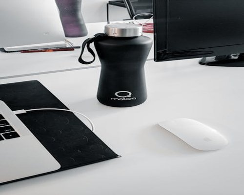 Termo de agua y taza de café en un escritorio